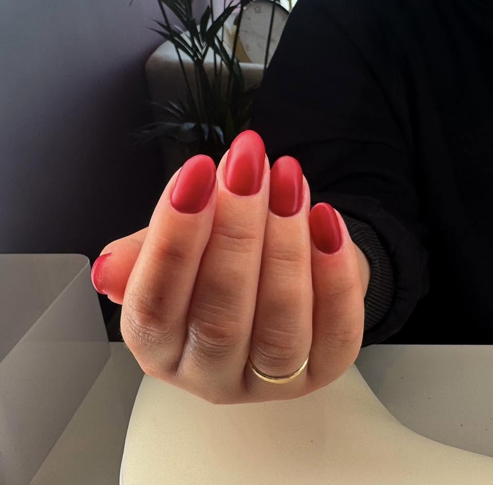 Czerwony manicure na paznokciach w kształcie migdała